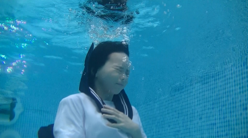 セーラー服を着たまま水中に潜る少女
