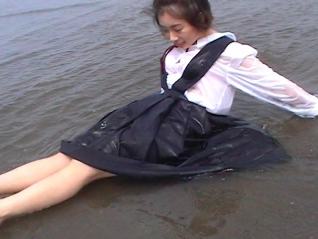 砂浜の水際で遊ぶ制服娘